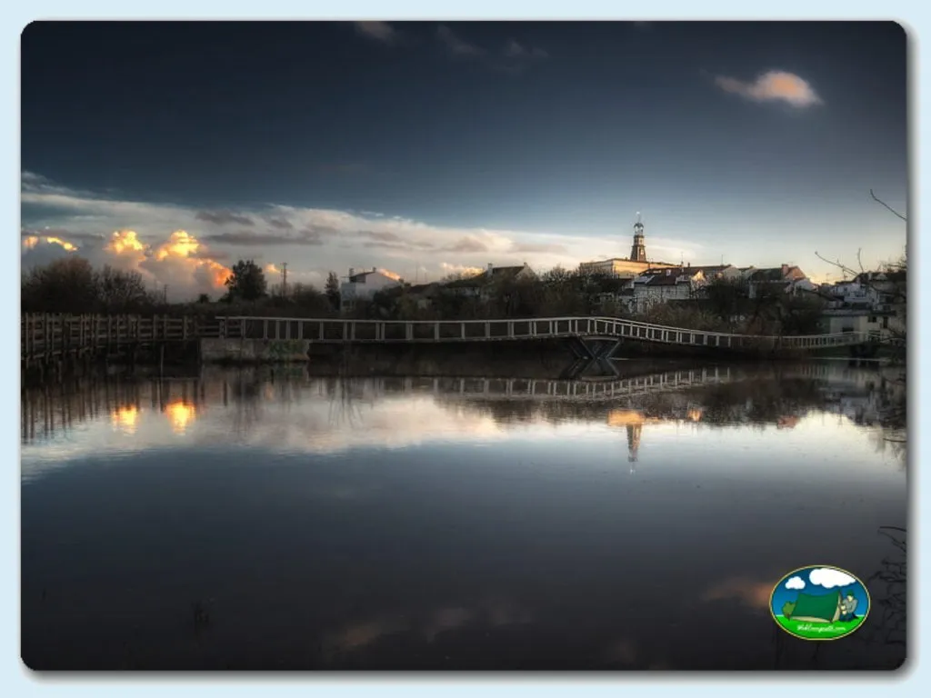 Río con puente y pueblo al atardecer del Camping Benavente, Santarém (Santarém)