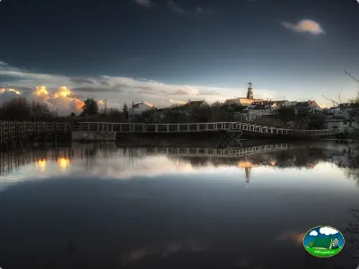 Río con puente y pueblo al atardecer del Camping Benavente, Santarém (Santarém)