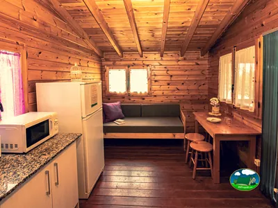 Cabaña de madera interior con cocina y zona de estar del Camping Ecocamp Vinyols, Vinyols i els Arcs (Tarragona)