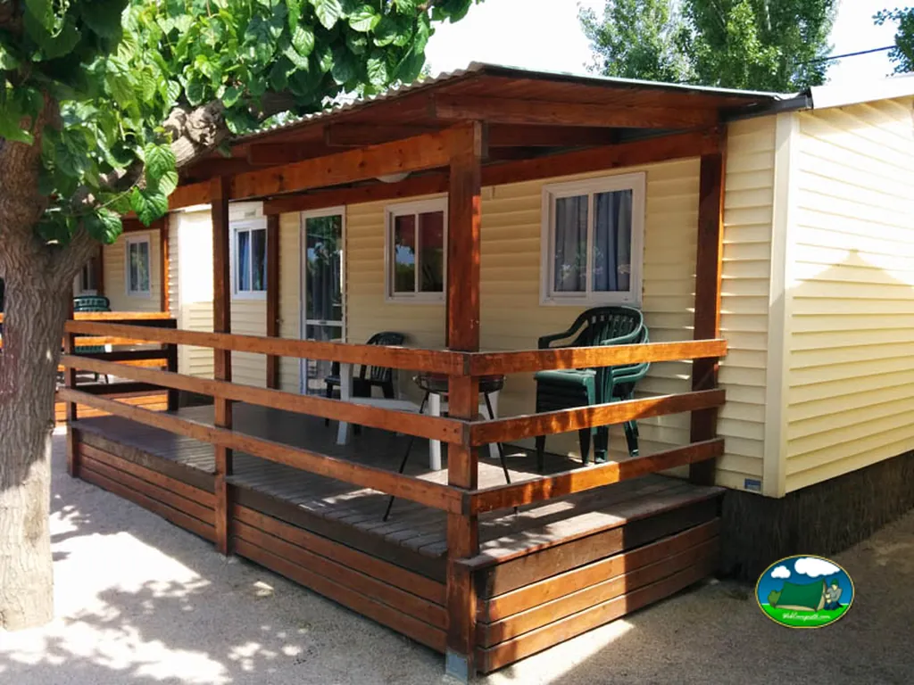 Mobil-home con terraza de madera y sombrilla del Camping Trillas Platja Tamarit, Tamarit (Tarragona)