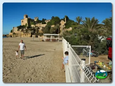 Playa junto al mar con ruinas históricas de fondo del Camping Tamarit Beach Resort, Tarragona (Tarragona)