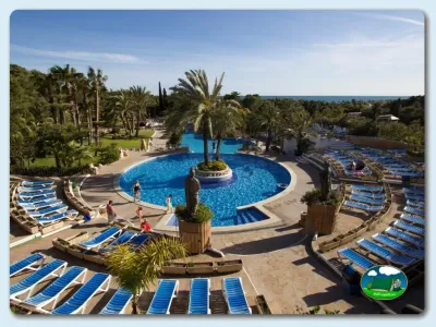 Piscina con vistas al mar rodeada de palmeras del Camping Park Platja Bará, RODA DE BARA – TARRAGONA (Tarragona)