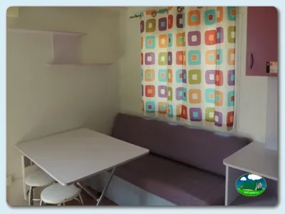 Mobil-home interior con zona de estar y cortinas decorativas del Camping El Carlitos, Arenys de Mar (Barcelona)
