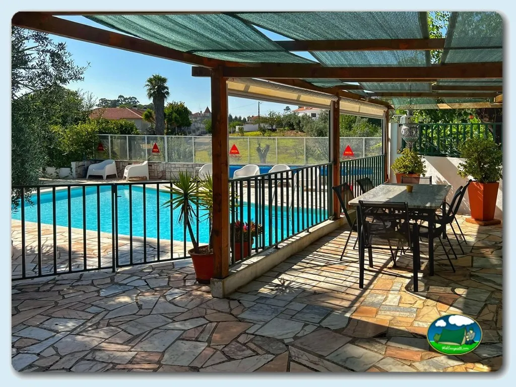 Piscina climatizada con zona de descanso y sombrilla del Camping Redondo, Poço Redondo (Santarém)