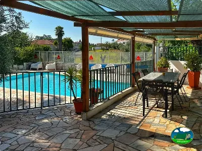 Piscina climatizada con zona de descanso y sombrilla del Camping Redondo, Poço Redondo (Santarém)