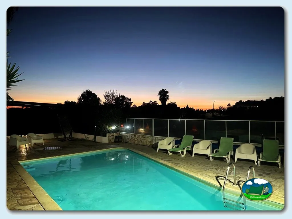Piscina iluminada al atardecer con tumbonas del Camping Redondo, Poço Redondo (Santarém)