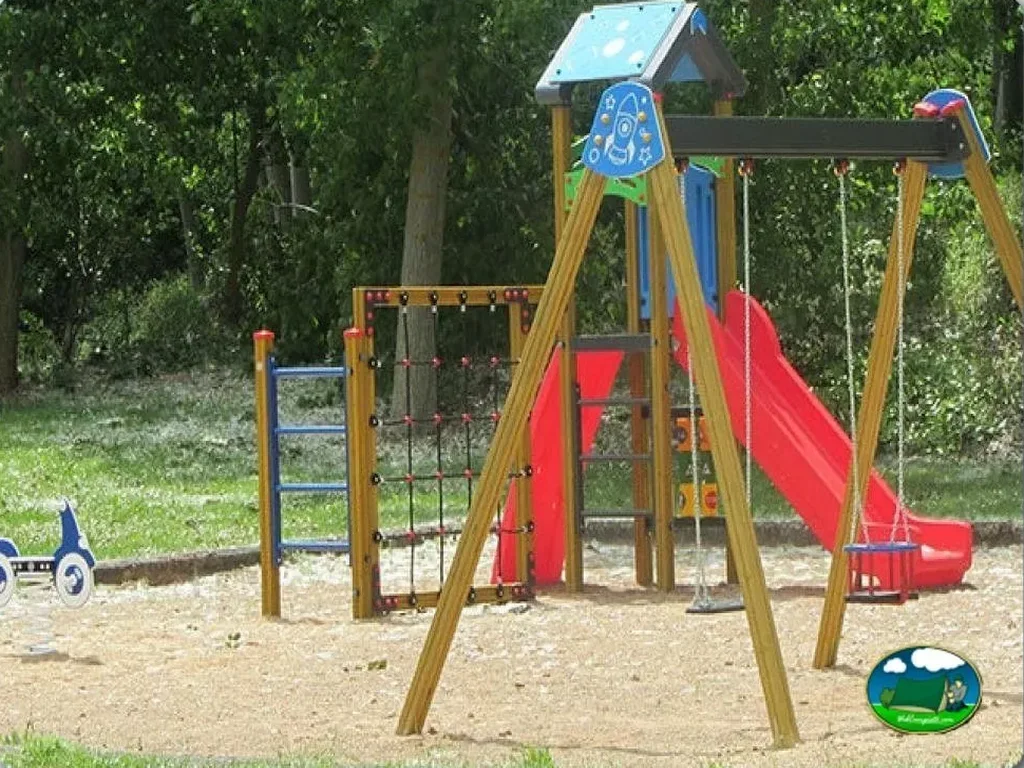 Parque infantil con tobogán rojo y columpios del Camping Berceo, Berceo (La Rioja)