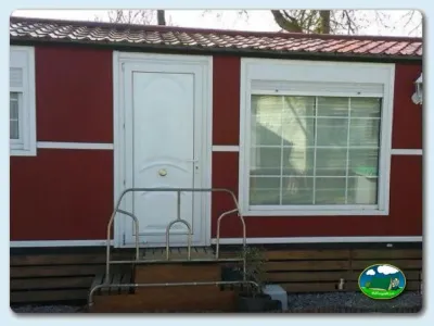 Mobil-home rojo y blanco con entrada y terraza del Camping Ibaya, Vitoria (Alava)