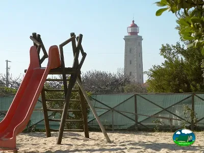 Parque infantil junto al mar con faro del Camping Inatel, Marinha Grande (Leiria)