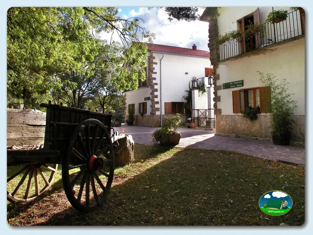 Recepción con arquitectura rural y carreta tradicional del Camping Urbasa Bioitza, Olazagutia (Navarra)