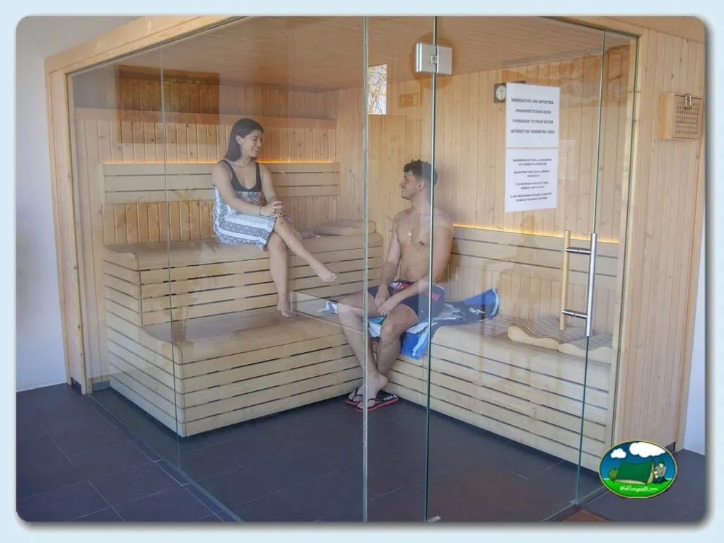 Sauna con dos personas en bancos de madera del Camping GRAN CAMPING ZARAUTZ, Zarautz (Gipuzkoa)