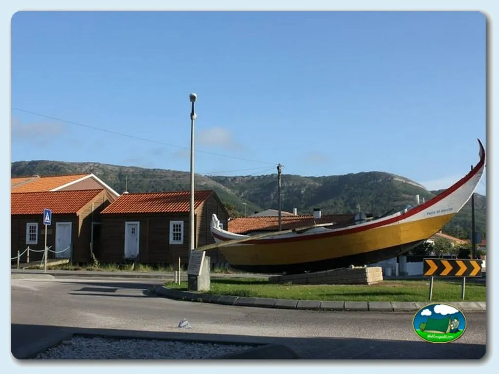 Río con barco tradicional y montaña de fondo del Camping Quiaios, Quiaios (Coimbra)