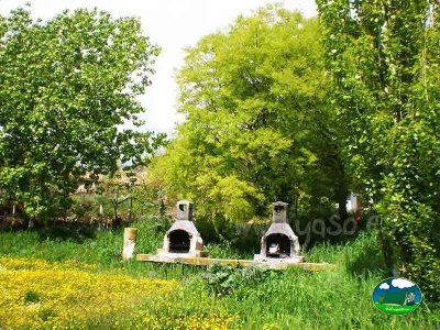 Área de picnic con chimeneas entre árboles del Camping Altaoja Guara, Yaso (Huesca)