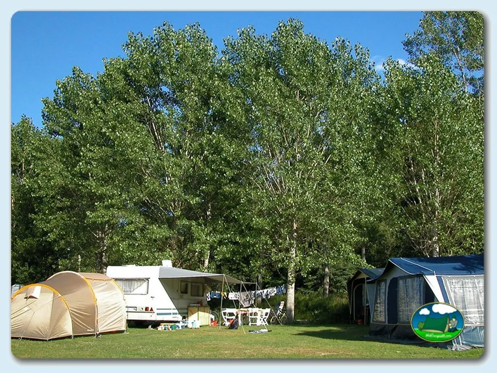 Parcela con tienda de acampada y mobil-home bajo árboles del Camping Urrobi, Navarra (Navarra)