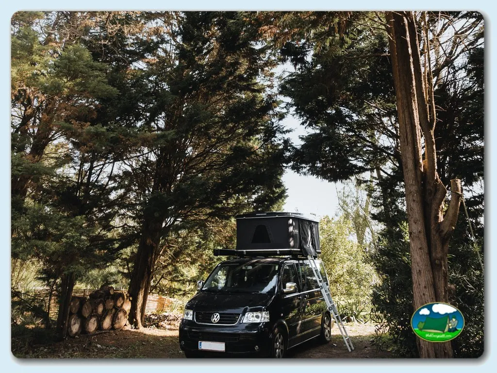 Parcela arbolada con tienda de campaña sobre vehículo del Camping O Tamanco, Louriçal (Leiria)