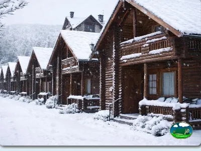 Cabañas de madera invierno con nieve y montaña del Camping Escarra, Escarrilla (Huesca)