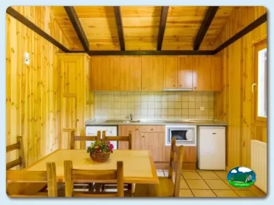 Cabaña interior con cocina y comedor de madera del Camping Gavín, Gavín (Huesca)