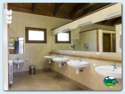 Aseos con múltiples lavabos y espejos del Camping Gavín, Gavín (Huesca)