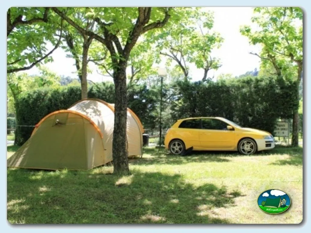 Parcela arbolada con tienda de acampada y coche del Camping Peña Montañesa, Labuerda (Huesca)