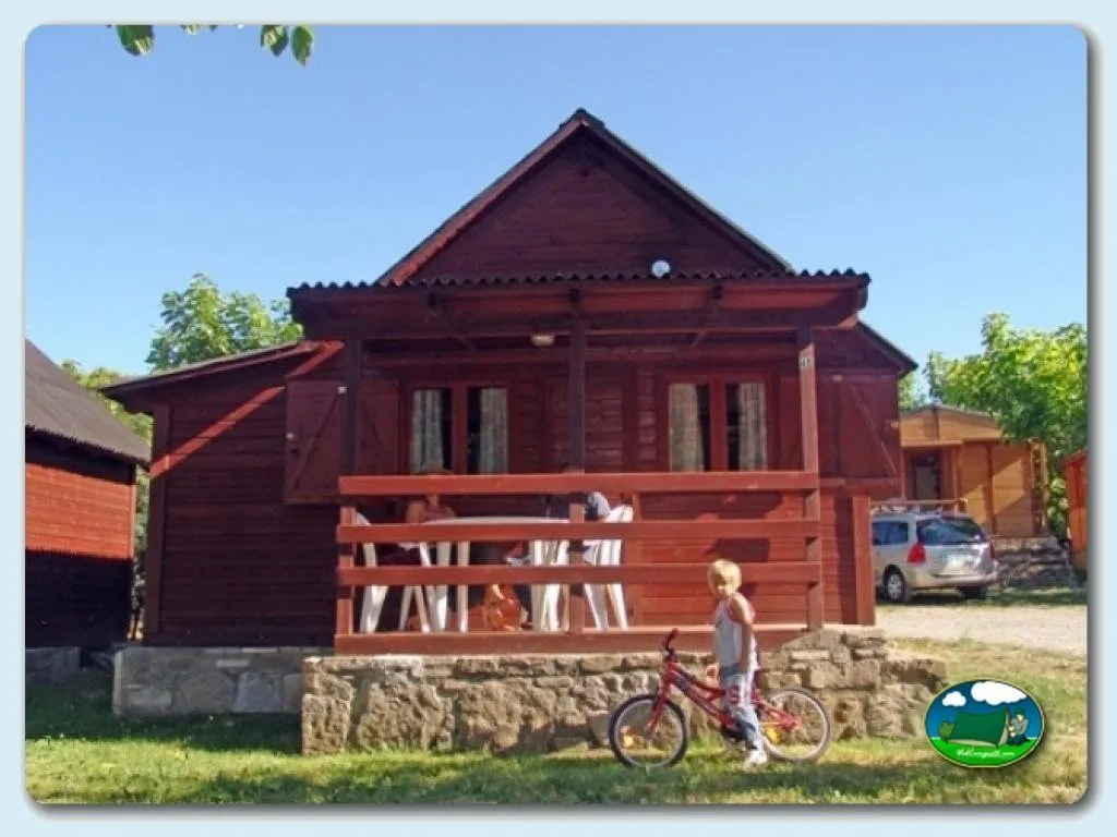 Cabaña de madera roja con terraza y zona infantil del Camping Peña Montañesa, Labuerda (Huesca)