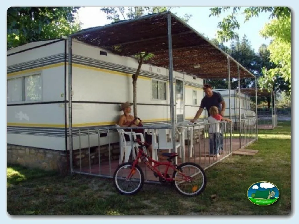 Mobil-home con terraza y sombrilla, zona de juegos infantiles del Camping Peña Montañesa, Labuerda (Huesca)