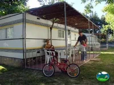 Mobil-home con terraza y sombrilla, zona de juegos infantiles del Camping Peña Montañesa, Labuerda (Huesca)