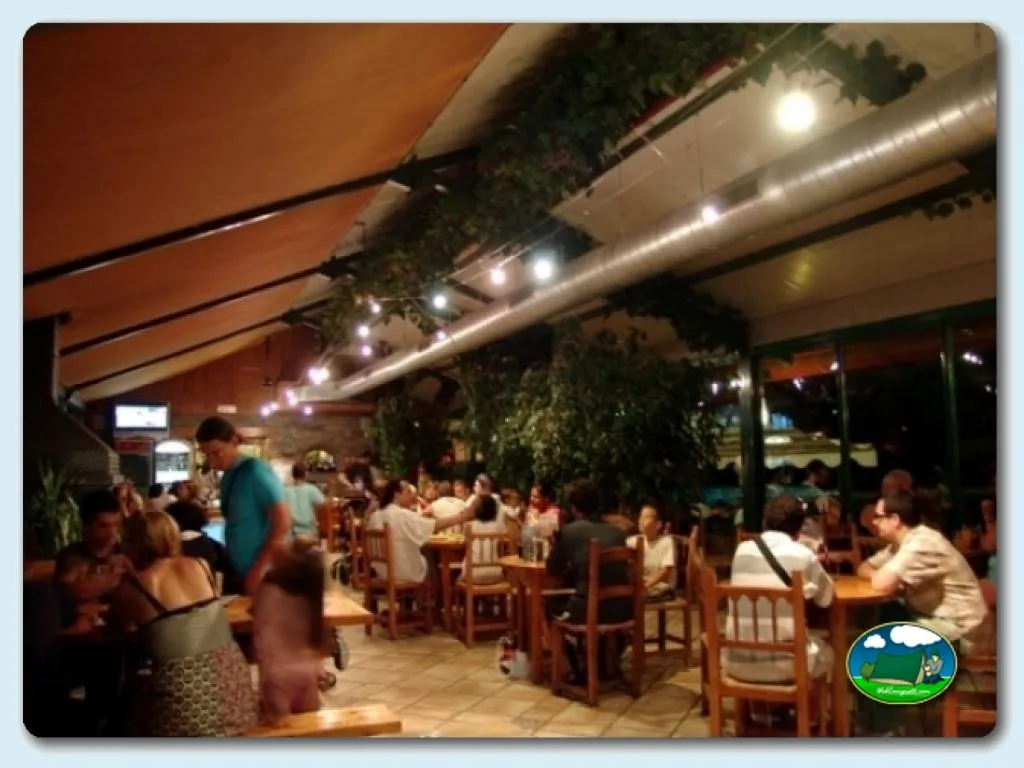 Restaurante con terraza cubierta y iluminación nocturna del Camping Peña Montañesa, Labuerda (Huesca)