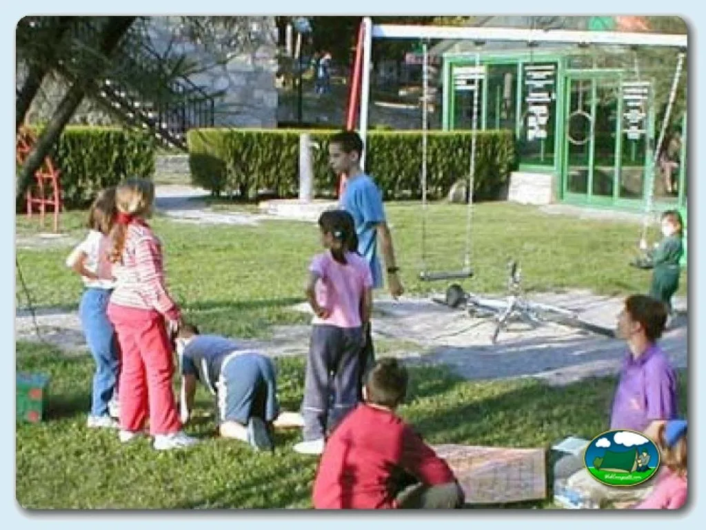 Parque infantil con niños jugando en zona de césped del Camping Peña Montañesa, Labuerda (Huesca)