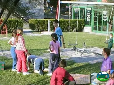 Parque infantil con niños jugando en zona de césped del Camping Peña Montañesa, Labuerda (Huesca)