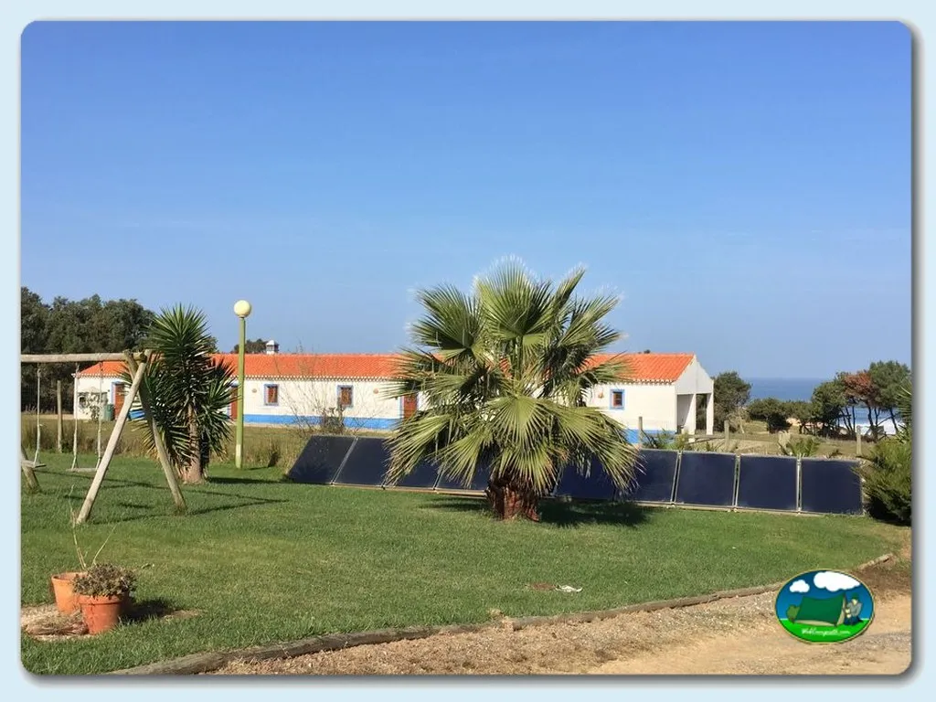 Piscina con vistas al mar, bungalows con tejado naranja del Camping Monte Carvalhal da Rocha, Odemira (Beja)