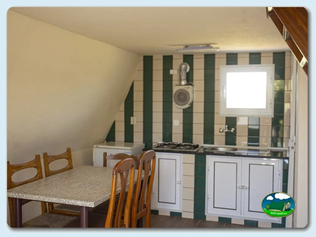 Cocina interior con mesa y sillas del Camping Costa Nova, Costa Nova (Aveiro)