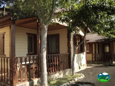 Bungalow con porche y vistas al jardín arbolado del Camping Lago Barasona, La Puebla de Castro (Huesca)
