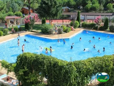 Piscina con zona de playa y vistas al entorno arbolado del Camping Lago Barasona, La Puebla de Castro (Huesca)