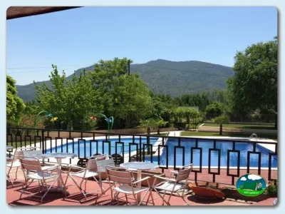 Piscina con vistas a la montaña y zona de descanso del Camping Lago Barasona, La Puebla de Castro (Huesca)