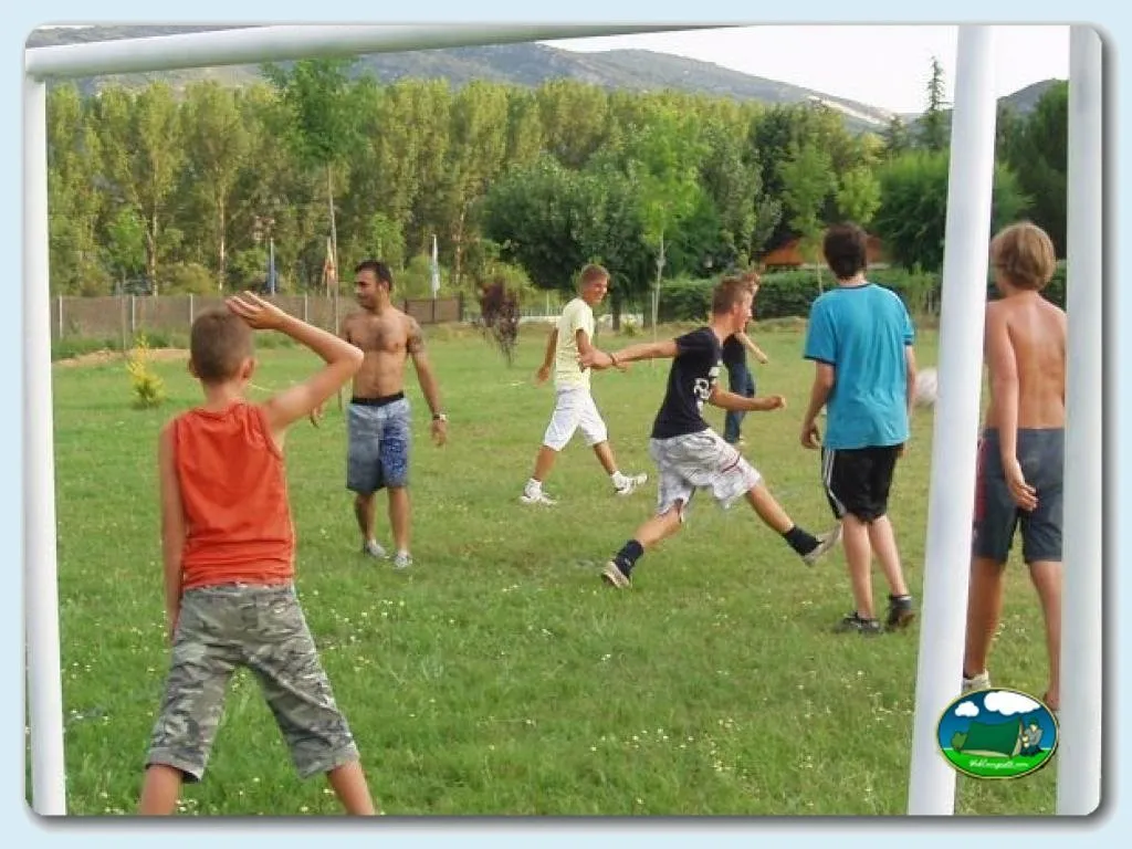 Parque infantil con niños jugando al fútbol del Camping Lago Barasona, La Puebla de Castro (Huesca)