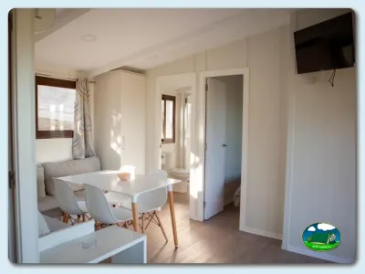 Mobil-home interior luminoso con zona de estar y comedor del Camping Lago Barasona, La Puebla de Castro (Huesca)