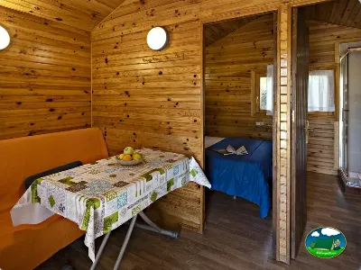 Cabaña de madera interior con dos camas y estar del Camping El Solsonés, Solsona (Lleida)