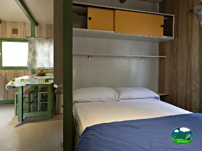 Bungalow interior con cama doble y zona de estar del Camping El Solsonés, Solsona (Lleida)
