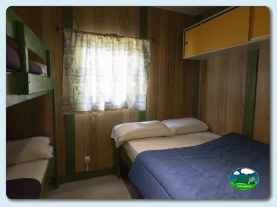 Mobil-home interior con camas y ventana del Camping El Solsonés, Solsona (Lleida)