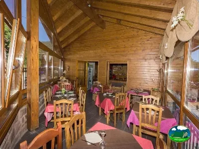 Restaurante con vistas panorámicas, techos de madera y decoración rústica del Camping Laspaúles, Castejón de Sos (Huesca)