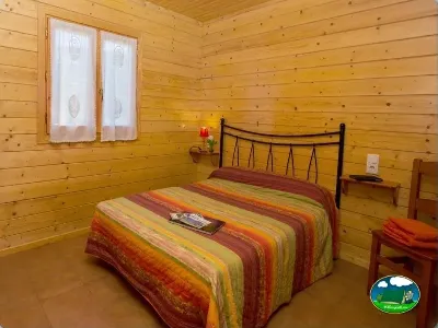 Cabaña interior con cama doble y ventanas del Camping Laspaúles, Castejón de Sos (Huesca)