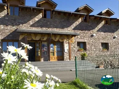 Recepción de piedra con flores blancas del Camping Laspaúles, Castejón de Sos (Huesca)