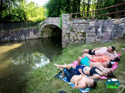 Río con puente de piedra y parcela junto al agua del Camping Laspaúles, Castejón de Sos (Huesca)
