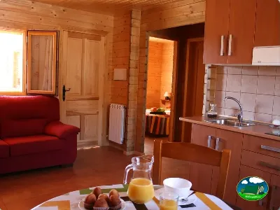 Cabaña interior con cocina, sofá y desayuno del Camping Laspaúles, Castejón de Sos (Huesca)