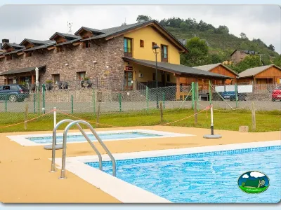 Piscina con vistas a la montaña y bungalows de madera del Camping Laspaúles, Castejón de Sos (Huesca)
