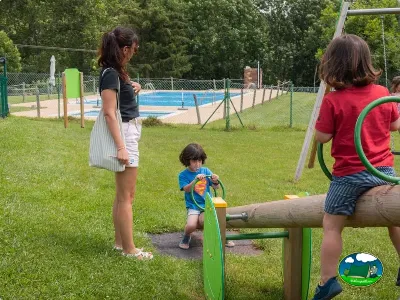 Parque infantil con piscina al fondo del Camping Laspaúles, Castejón de Sos (Huesca)