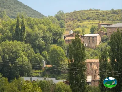 Sierra con casas de piedra y cipreses del Camping Laspaúles, Castejón de Sos (Huesca)