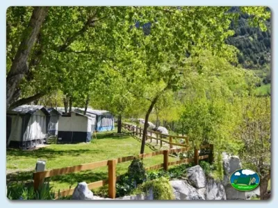 Parcela arbolada junto a río con tienda de acampada del Camping Aneto, Benasque (Huesca)