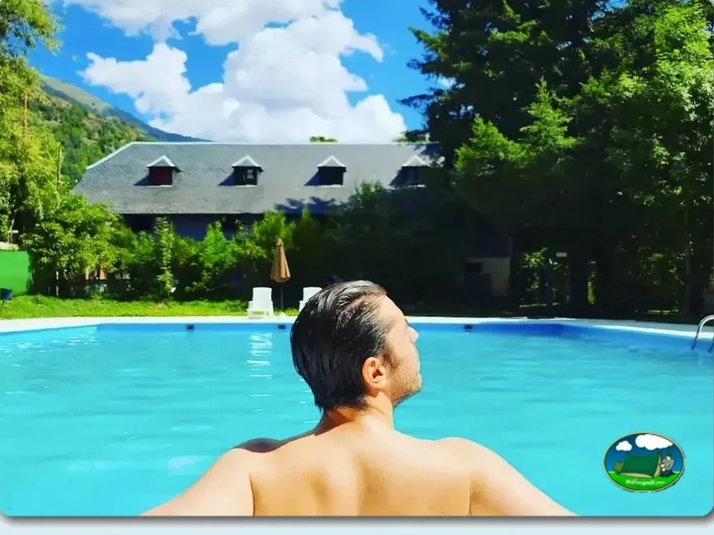 Piscina con vistas a la montaña y edificio principal del Camping Artigane, Arán (Lleida)