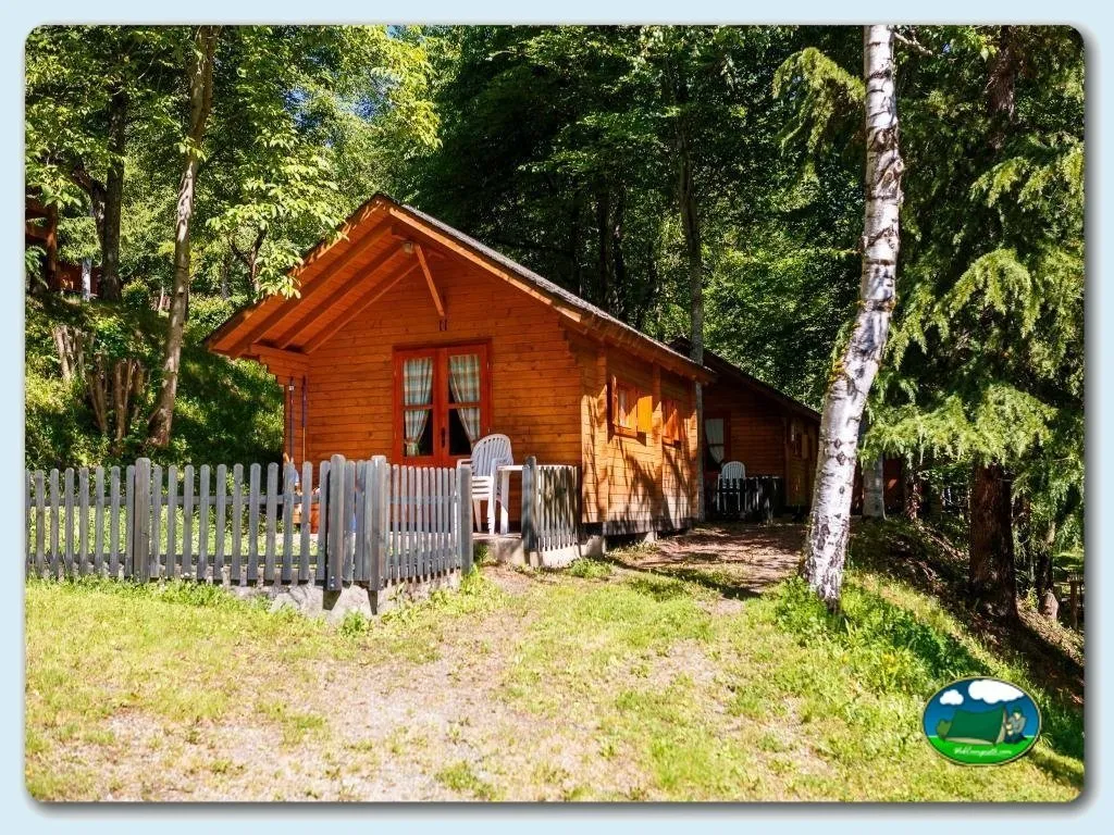 Cabaña de madera entre árboles con cerca y terraza del Camping Bedura Park, Val D'Aran (Lleida)